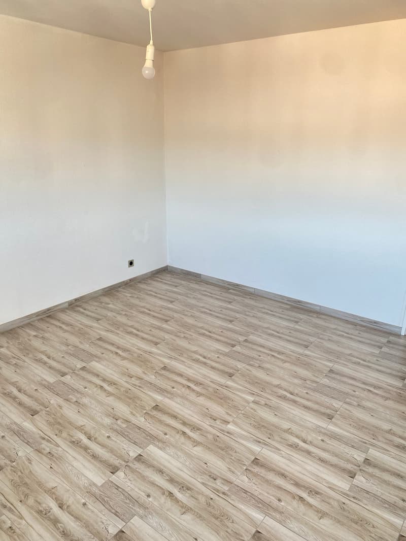 empty room, wooden floor, white walls, power outlet on the wall