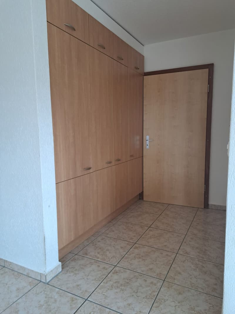 Empty room with wooden cabinets and tiled floor