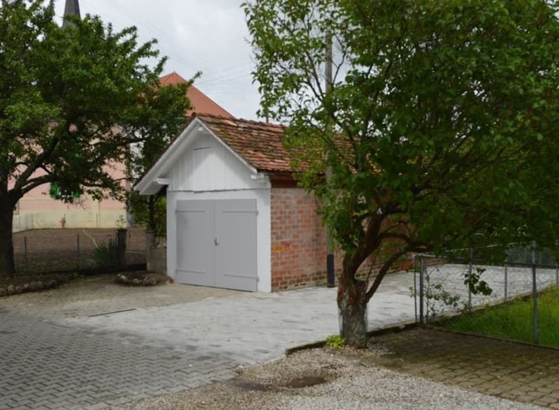 single car brick garage, paved drive, trees, fence