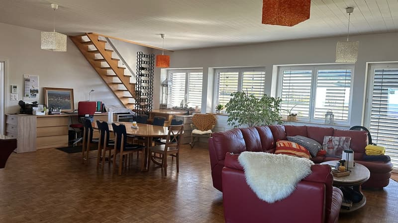 6 windows, staircase, desk, 4 chairs, round table, armchair, leather couch, coffee table, shelves