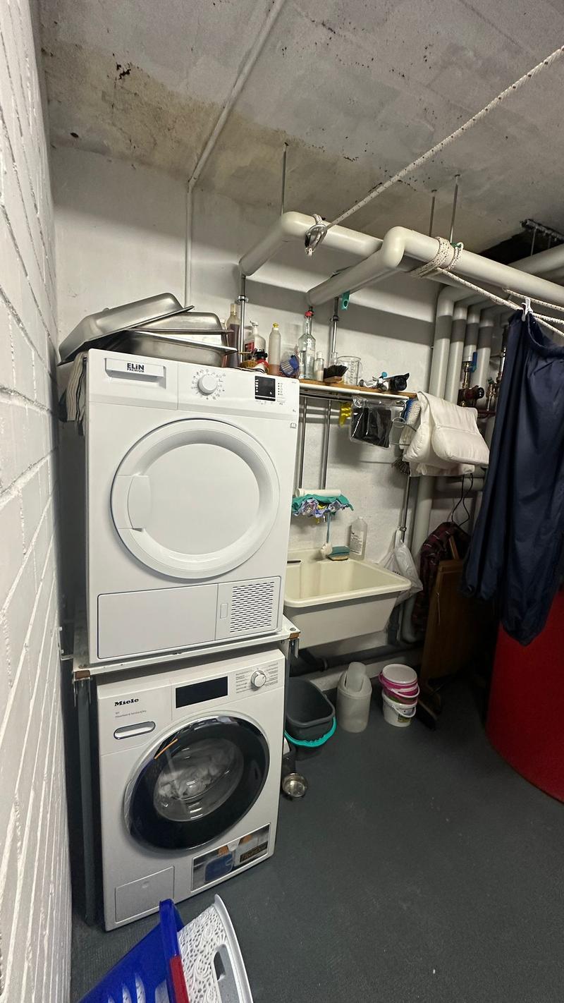 White floor, metal pipe, tiled wall, washing machine, sink, storage box, buckets