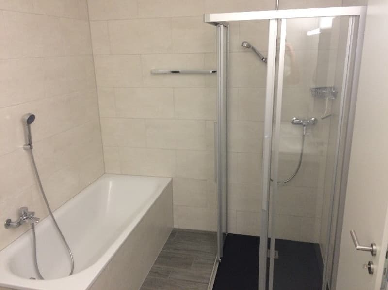 Bathroom with bathtub, shower, and tiled walls