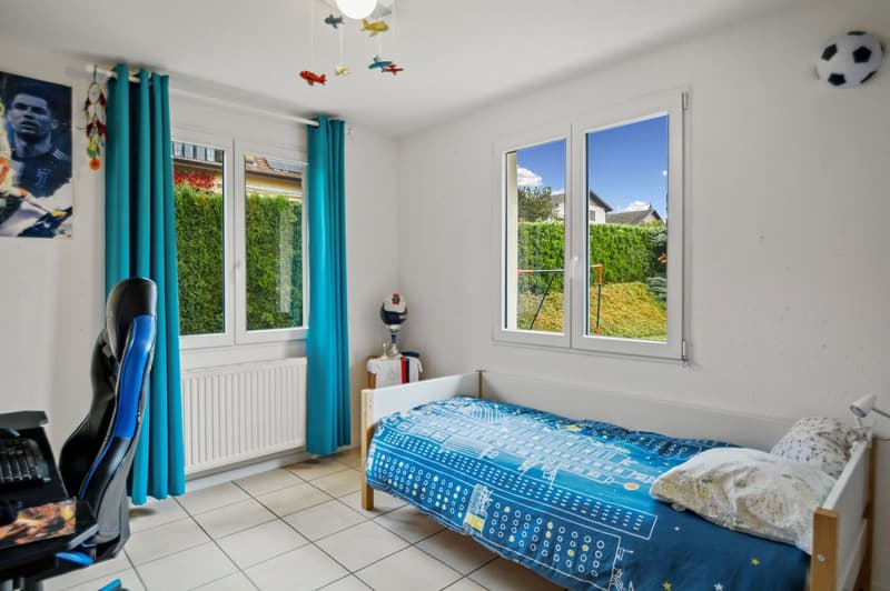 single bed with blue bedding, white tile flooring, blue curtains, gaming chair, white radiator