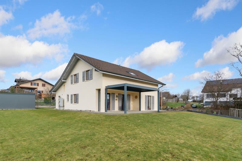 Two story house, white with brown roof, glass windows, double garage, fenced yard