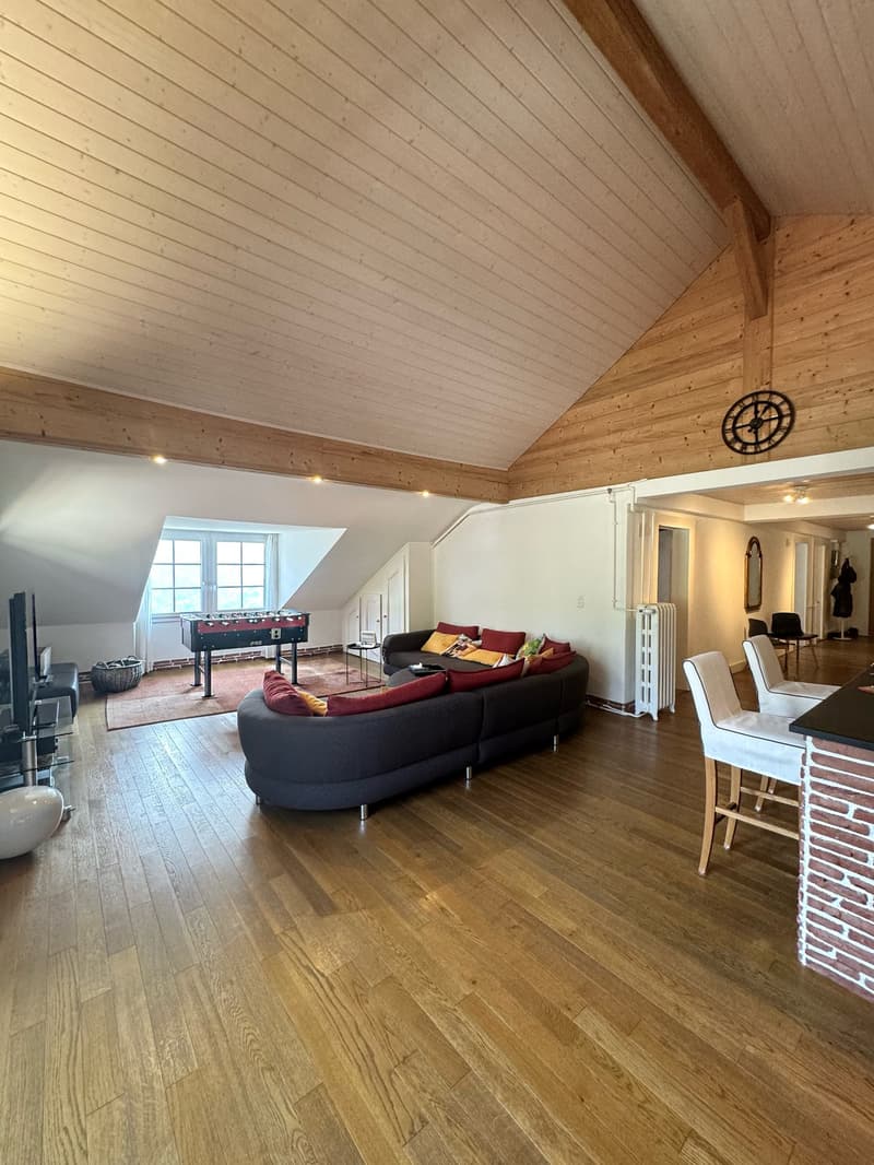 Spacious attic room, wooden floors, L-shaped couch, table football, TV, mirror