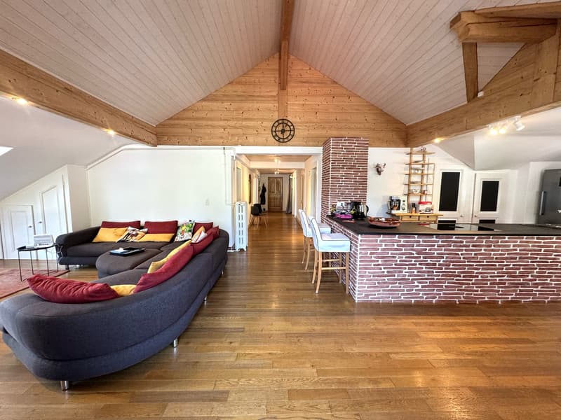 spacious living room with U-shaped sofa, wooden floor, bar counter, brick chimney, wooden beams
