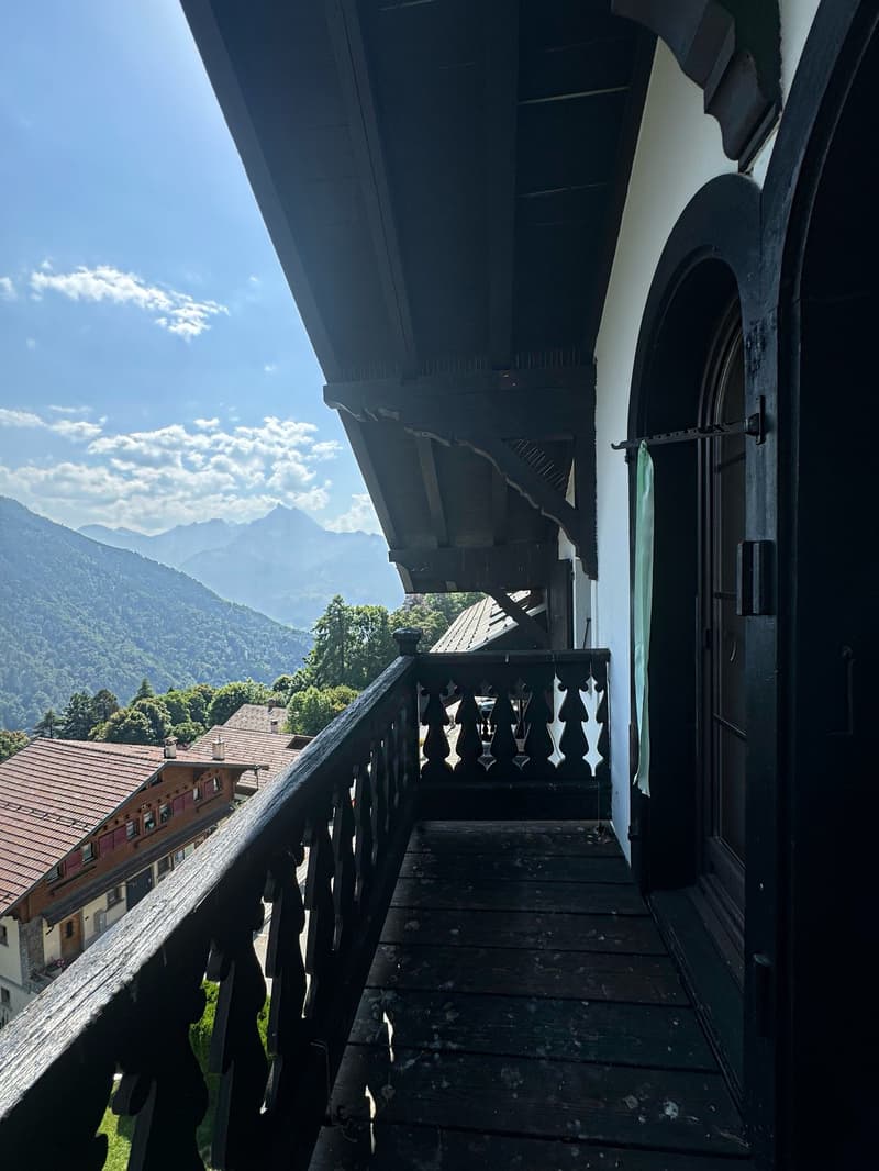 wooden balcony, mountain view, blue sky, clear clouds