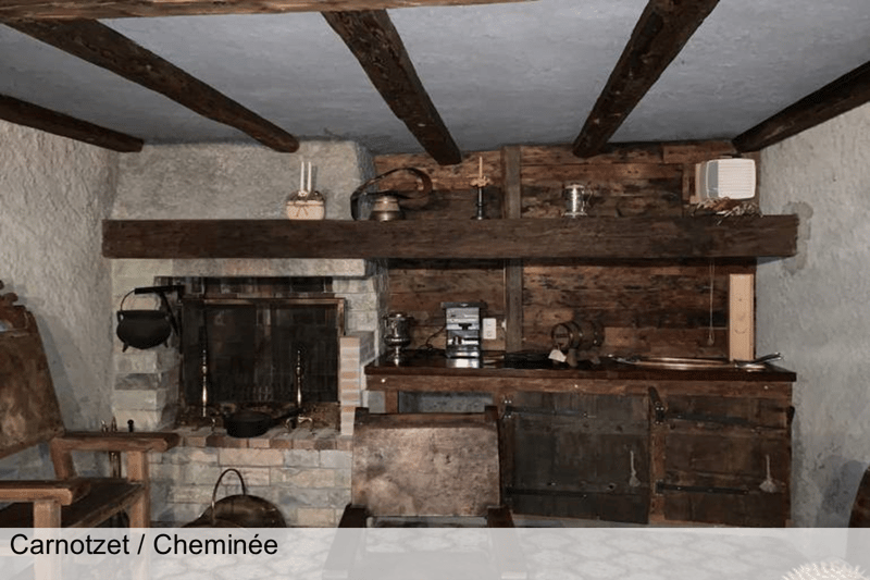 Rustic style room with exposed wooden beams, a fireplace, and antique-style furnishings.