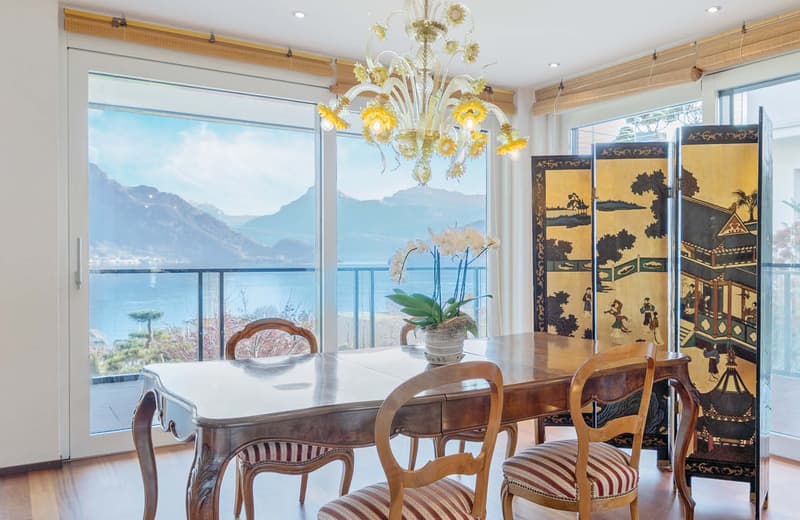a wooden table, 4 chairs, a wooden screen, a chandelier, a flower vase, balcony