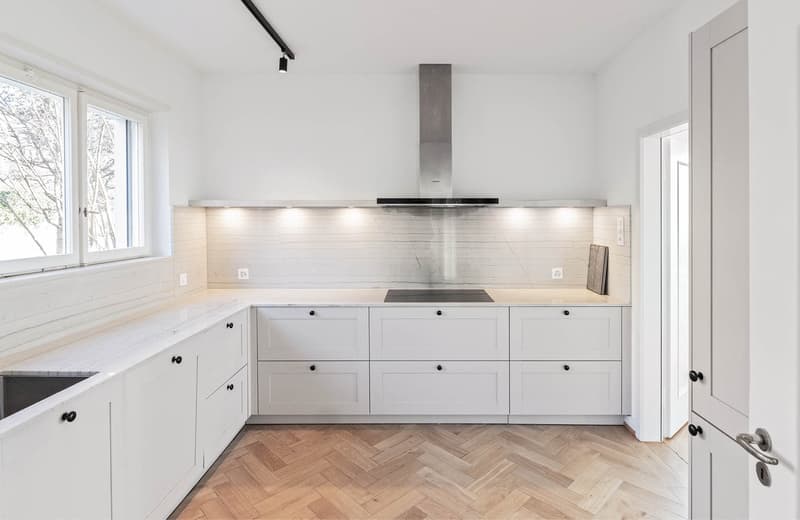 modern design, white cabinets, marble countertop, stainless steel appliances, wooden flooring, under cabinet lighting, stainless steel chimney