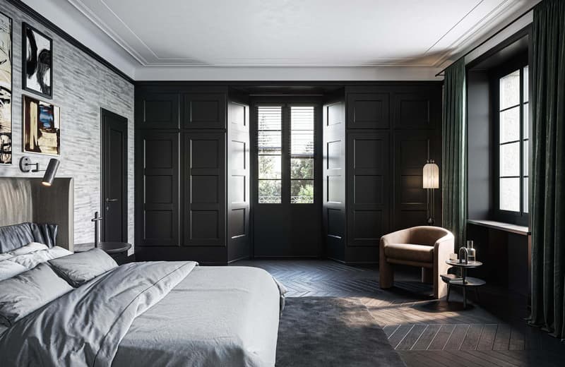 Modern bedroom with black walls, wooden floor, bed, armchair, lamp, artwork