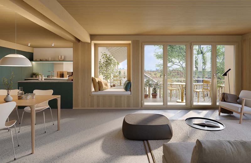 Open-concept living space with kitchen, dining area, and living room. Large windows and sliding glass doors leading to a balcony or terrace with views of the surrounding greenery. Wooden ceiling, neutral color palette, and modern furnishings.