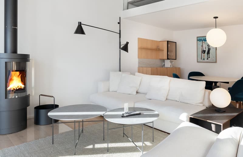 Modern living room with white couch, fireplace, floor lamps, center tables, round dining table and chairs