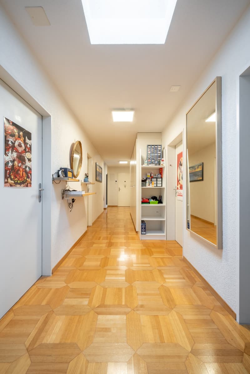 geometric parquet flooring, illuminated hallway, decorative mirrors, ceiling with lights, wall mounted shelves