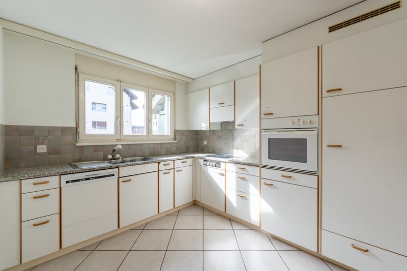 modern kitchen with white cabinets, granite countertops, dishwasher, washing machine, oven, and a sink with a faucet