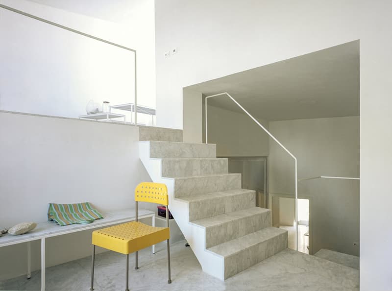 White marble stairs, yellow chair, stone countertop, marble flooring, modern design
