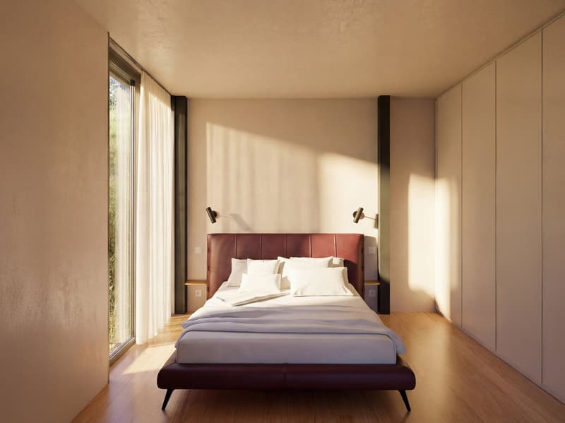 A bedroom with a large bed, white walls, wooden floor, large windows, and a view of the outside.
