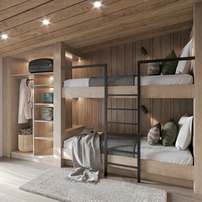A room with wooden walls and floors, featuring a set of three bunk beds with wooden frames and gray bedding. Below the top bunk is a desk with a laptop and a blanket, and a railing leads to the bottom bunk. Adjacent to the beds is a closet with a hanger a