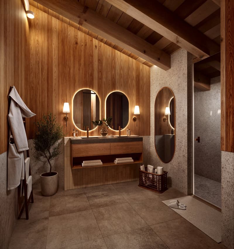 Double sink vanity, two round mirrors, wooden closet, hanging clothes, large plant, basket with towels, slippers, large tile floor