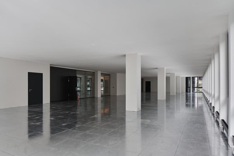 modern office space, large entrance, white walls, tiled floor, large windows, white columns