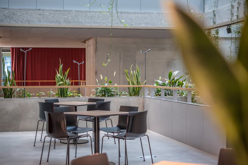 tables and chairs on an outdoor dining area with a balcony