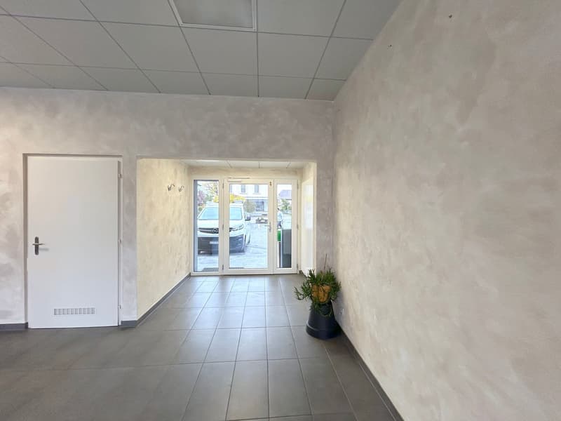 White walls, white doors, tiled floor, sliding glass doors, and plant in the corner.
