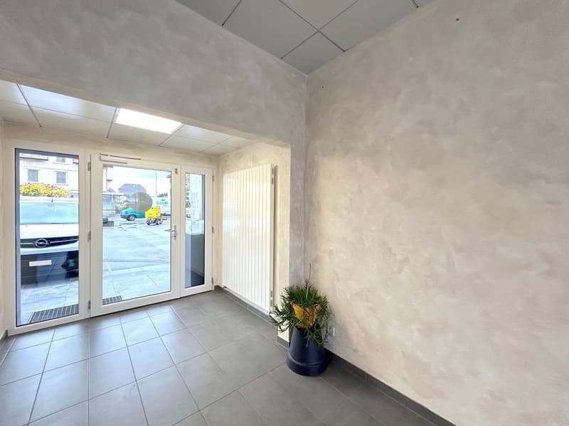 Entryway with sliding glass doors, white tiled floor, white walls, white ceiling, sliding door, radiator, potted plant, tiled flooring.