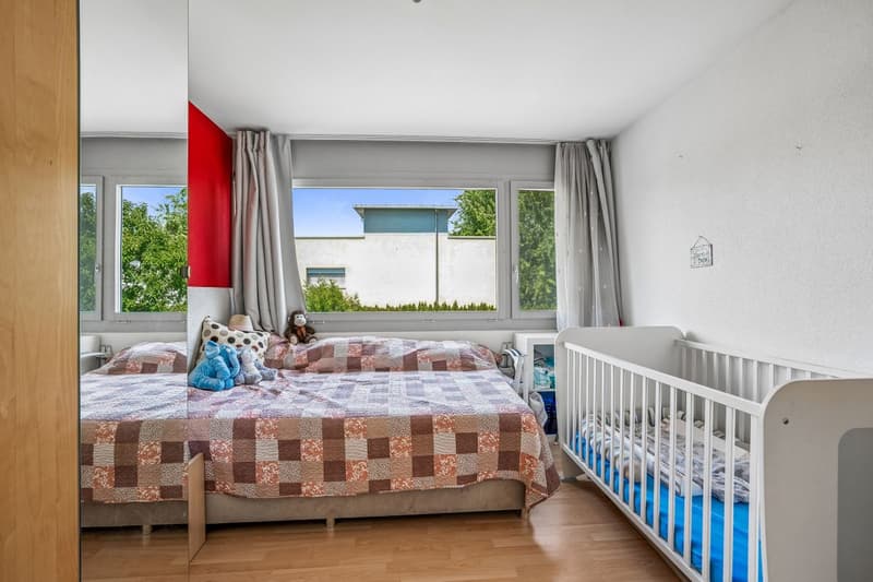 Gemütliches und helles Kinderzimmer mit grosser Fensterfront.