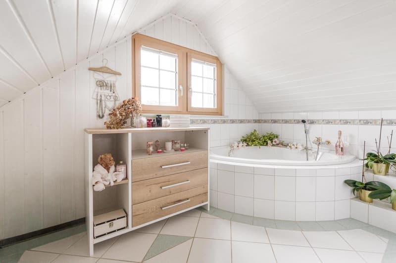 white tiled floor, beige ceiling, bathtub, wooden cabinet, white walls, glass windows