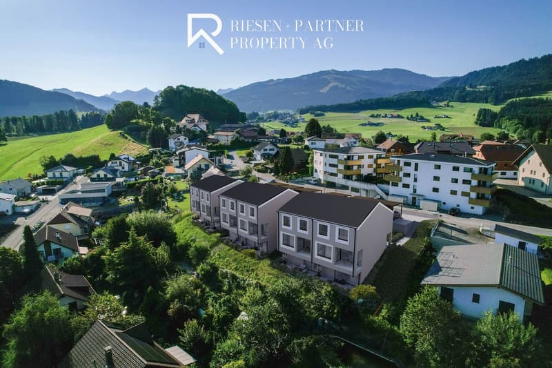 Newly built residential complex, modern design, gray roofs, raised ground floor, balconies, surrounded by greenery