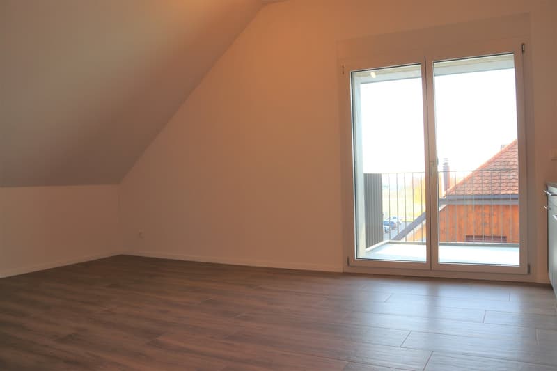 empty room with sliding doors, wooden floor, white walls, balcony view, small electrical outlet