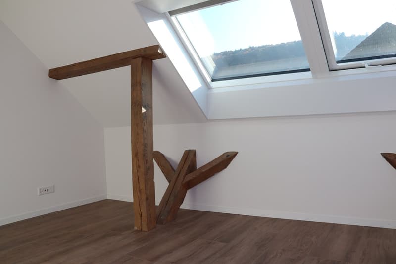 empty room, wooden floor, white walls, wooden beams, skylight window