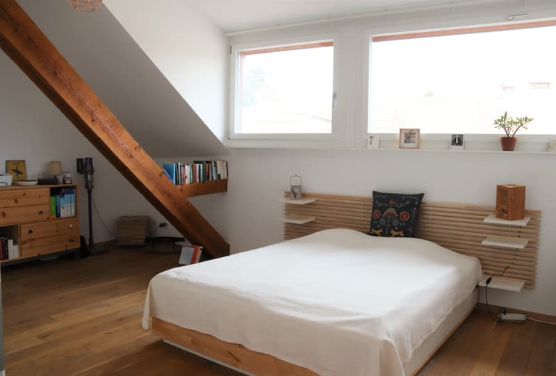 bedroom with wooden bed, wooden shelves, wooden floor, wooden beams, books, lamp, power outlet, window