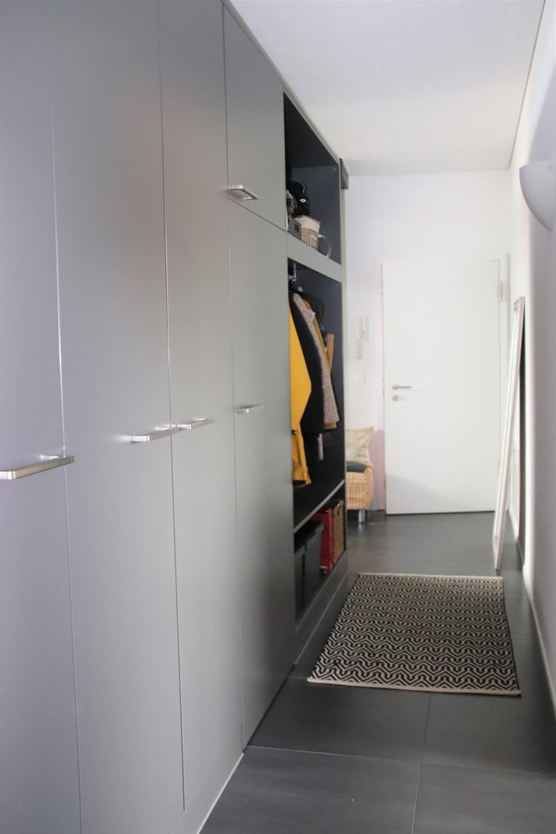 Large wardrobes, open wardrobe with clothes, rug, white door