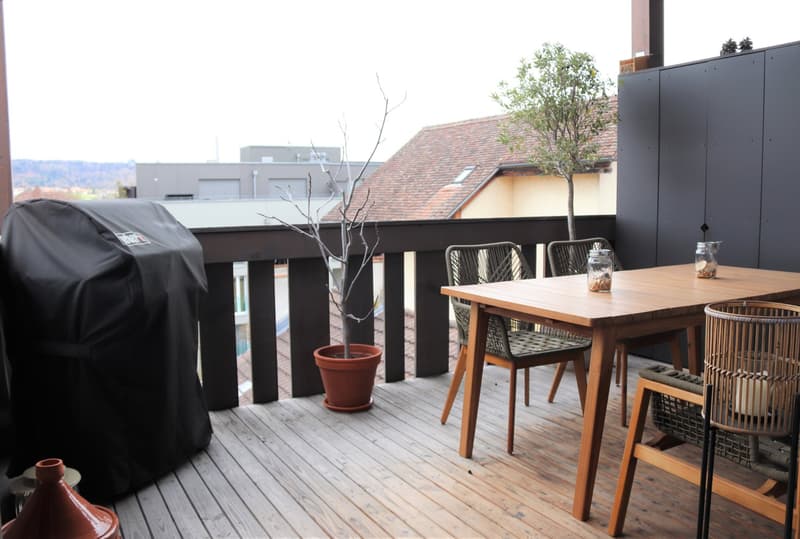 wooden deck, table, chairs, grill, potted plants, storage cabinets, view of the city