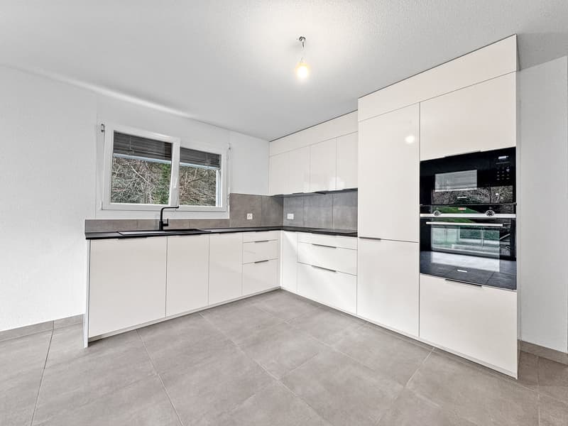 white cabinets, black countertops, silver stove and oven, white sink, faucet