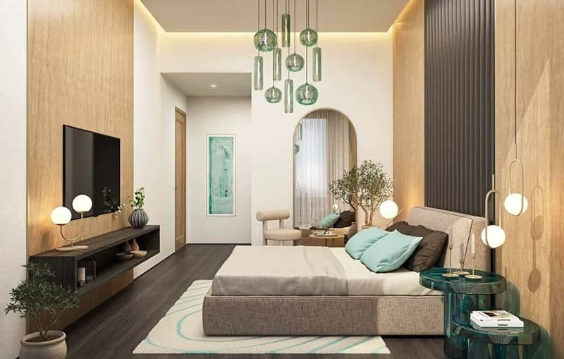 large bed, bedspread, pillows, bedside tables, lamps, armchair, TV, wooden cabinet, plants