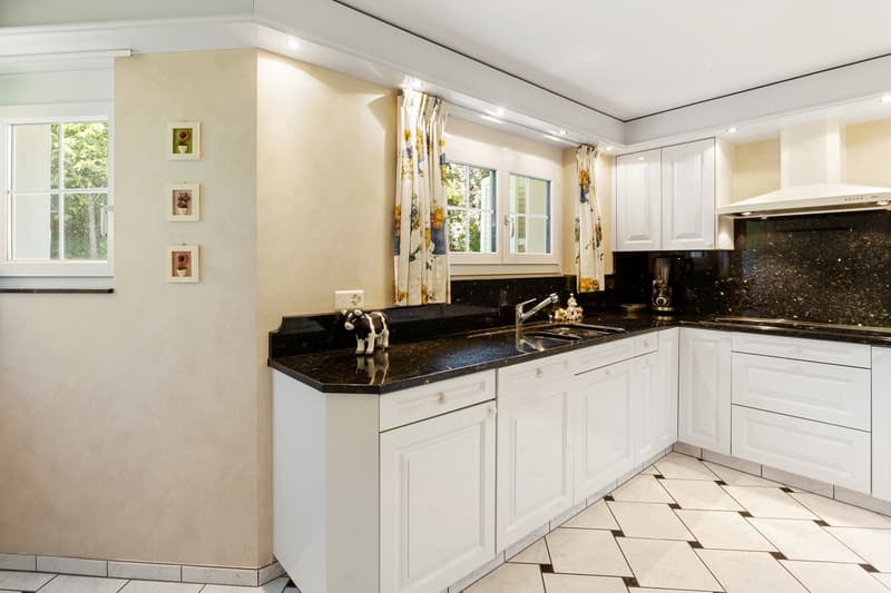 modern kitchen with white cabinets, black granite countertops, stainless steel sink, white tiled floor, windows with curtains