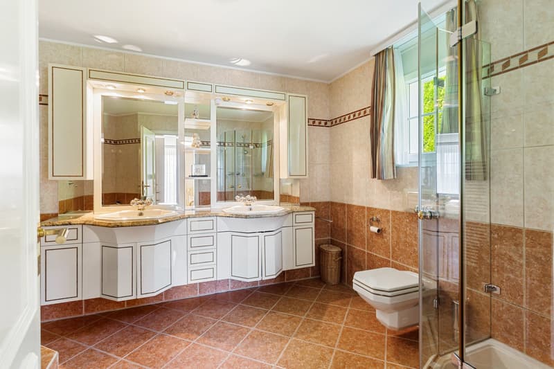 Double sink vanity, large mirror, shower enclosure, toilet, bathtub, tiled floor, window with curtain