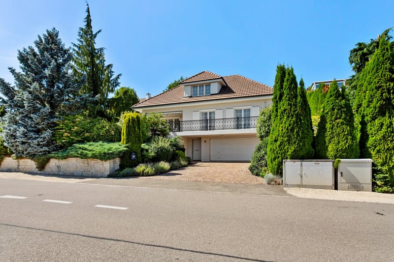 2 story house, brown roof, white walls, balcony, garage, driveway, garden