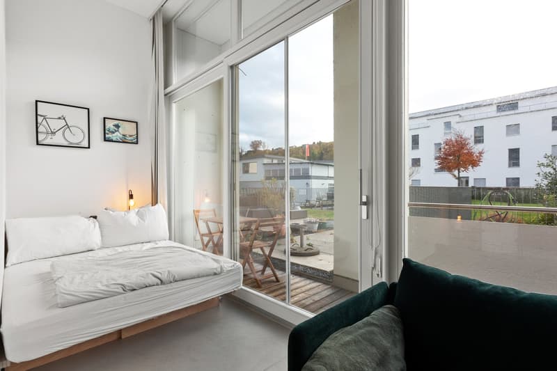 single bed, couch, sliding glass doors, balcony, picture frames, lamp