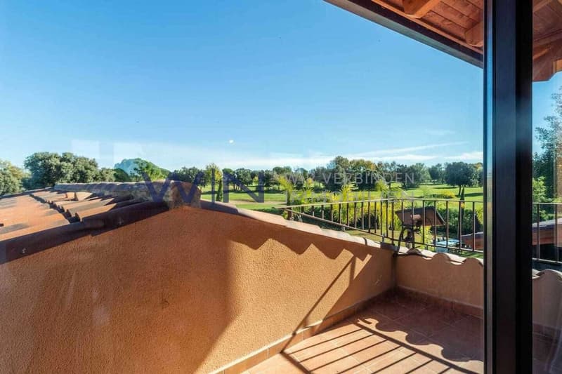The office has a library with books and views of the outdoor garden.