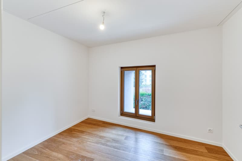 empty room, white walls, wooden floor, single window, light fixture