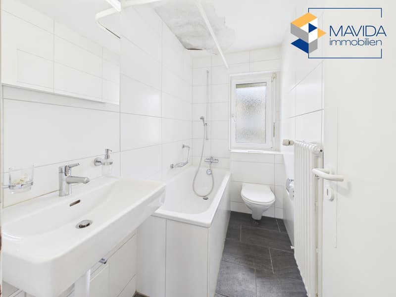 white tiles, white sink, bathtub, toilet, radiator, window