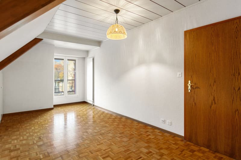 Empty room, parquet floor, white walls, pendant lamp, radiator, window with balcony