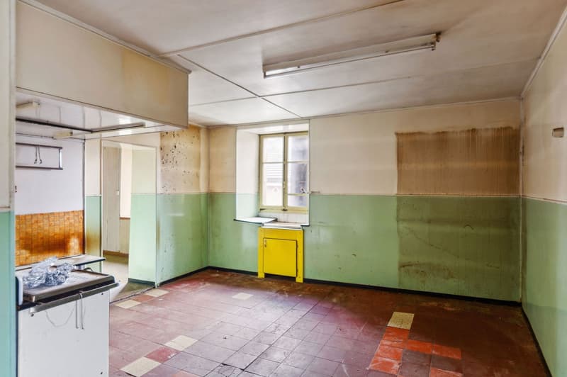 empty room, tiled floor, green and white walls, window, yellow cabinet, ceiling lights