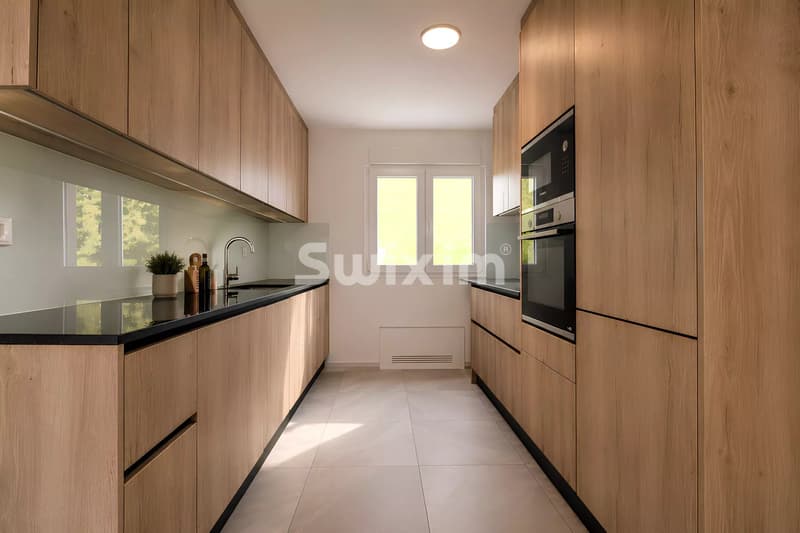 Cuisine moderne avec beaucoup de rangement et de lumière naturelle.