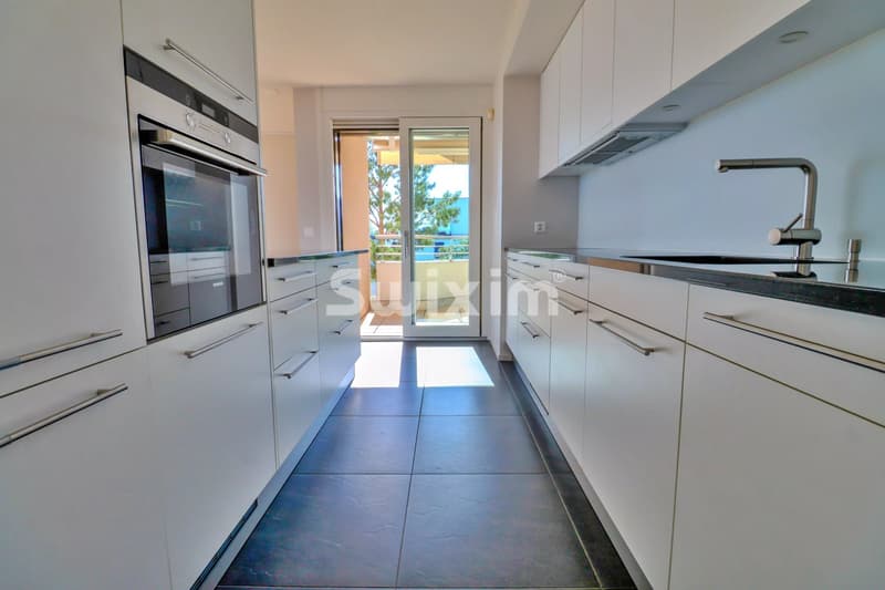 Cuisine moderne lumineuse avec vue sur l'extérieur.