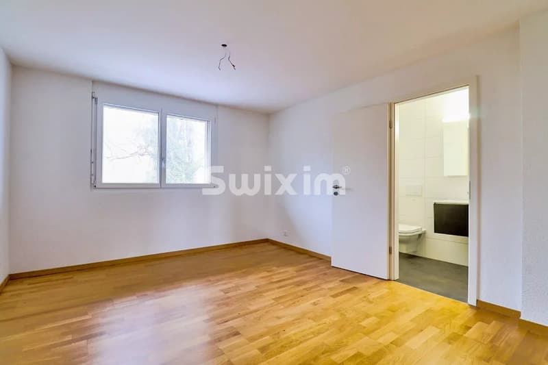 Suite parentale  avec parquet, une fenêtre, et une porte ouverte vers une salle de bain.