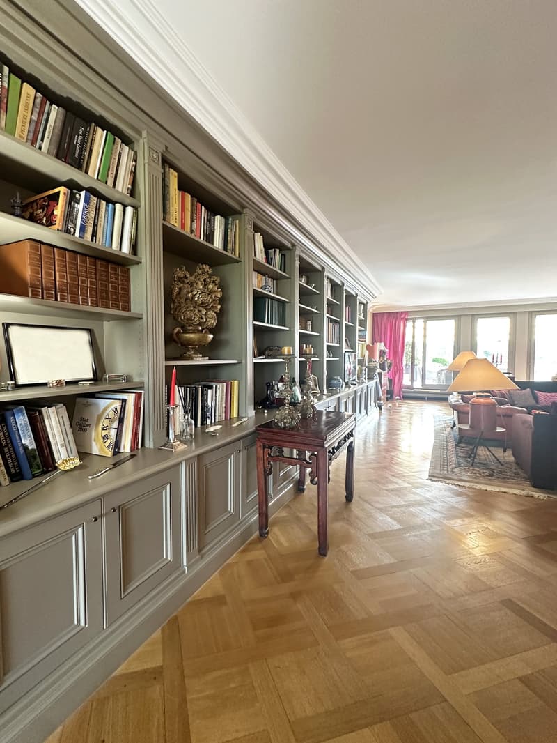 Floor to ceiling bookcases, parquet flooring, large hallway, fireplace, sofa, carpet, lamp